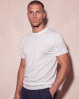 Man in white knit t-shirt with hand on hip, Morengar menswear