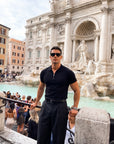Man in black half-zip knit polo, full outfit outdoors