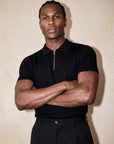 Man in black knit polo with arms crossed, Morengar menswear