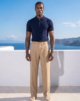 Man in navy half-zip knit polo with beige trousers, full summer look