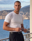 Man in white knit t-shirt outdoors by the sea, Morengar summer style