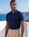 Man wearing navy knit polo by the sea, Morengar summer menswear