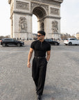 Man in black half-zip knit polo and tailored trousers at the Arc de Triomphe, Paris — Morengar menswear