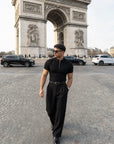 Man in black half-zip knit polo and tailored trousers at the Arc de Triomphe, Paris — Morengar menswear