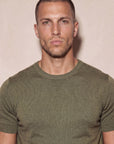 Man wearing olive green Morengar knit t-shirt, close-up