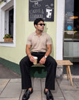 Man in beige knit polo sitting outdoors, Morengar summer style