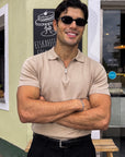 Man in beige knit polo with sunglasses, arms crossed, Morengar menswear