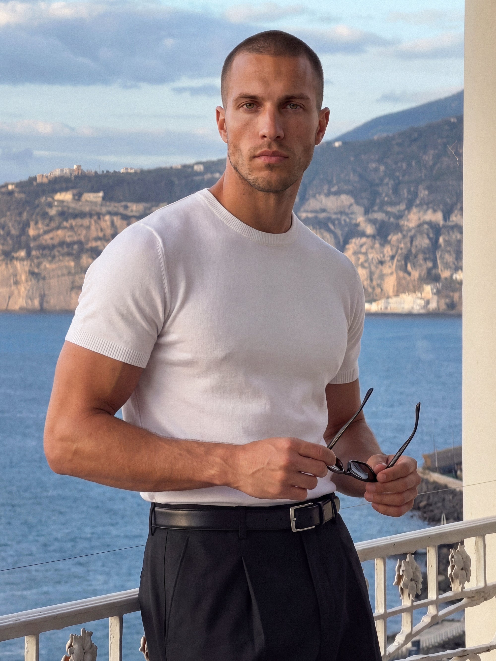 Man in white knit t-shirt outdoors by the sea, Morengar summer style