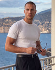Man in white knit t-shirt outdoors by the sea, Morengar summer style
