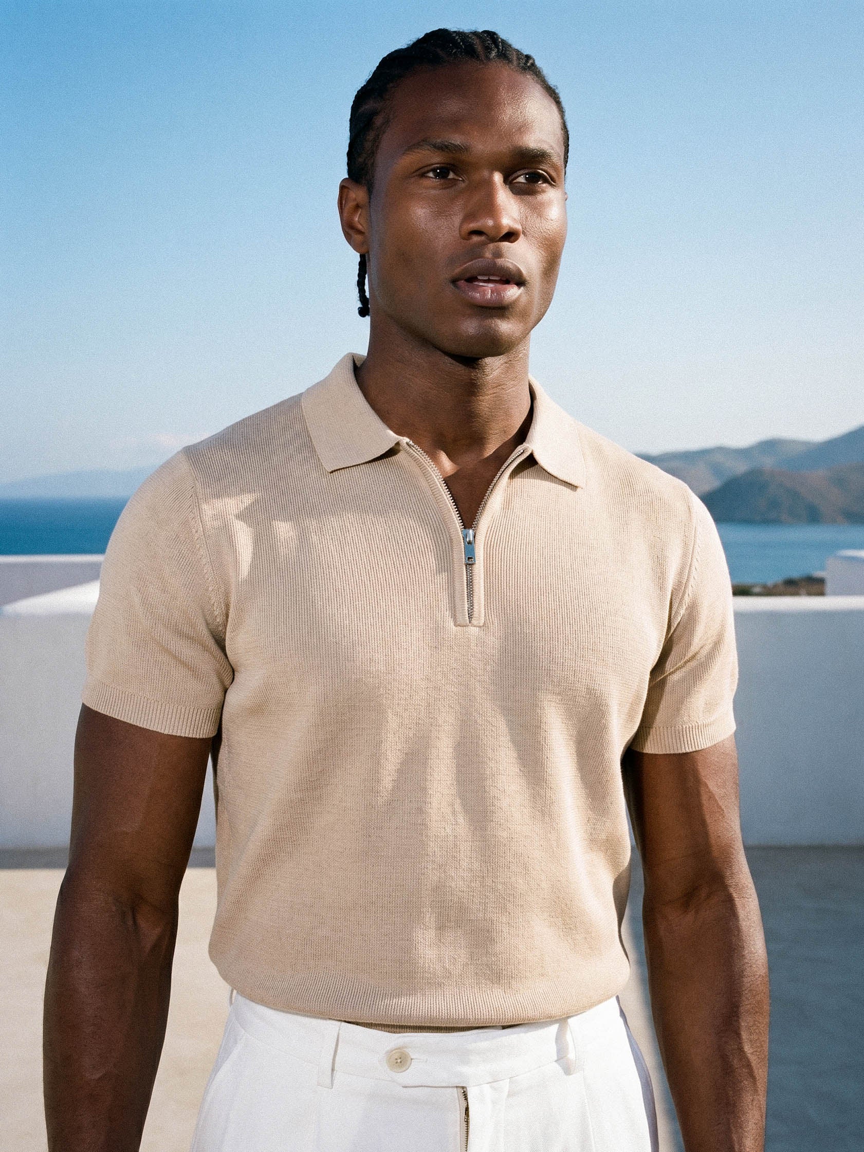 Man wearing beige knit polo by the sea, Morengar summer menswear
