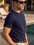 → "Man wearing navy knit t-shirt by the pool, Morengar summer menswear