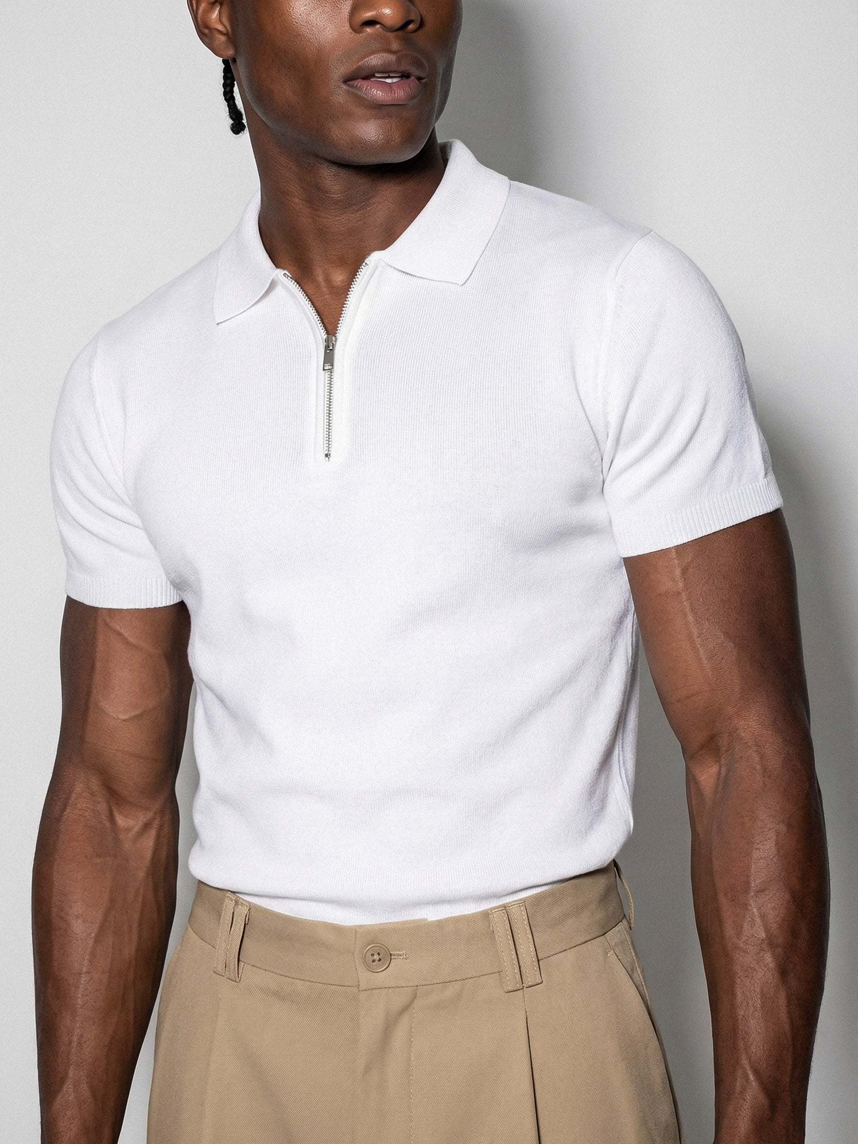Man wearing white Morengar polo with beige tailored trousers