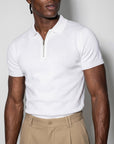 Man wearing white Morengar polo with beige tailored trousers