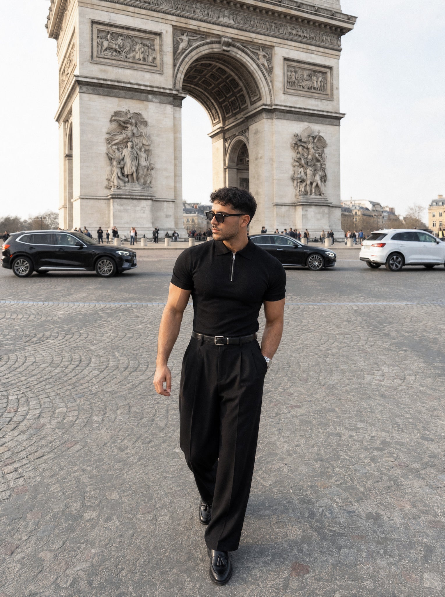 Man in black half-zip knit polo and tailored trousers at the Arc de Triomphe, Paris — Morengar menswear