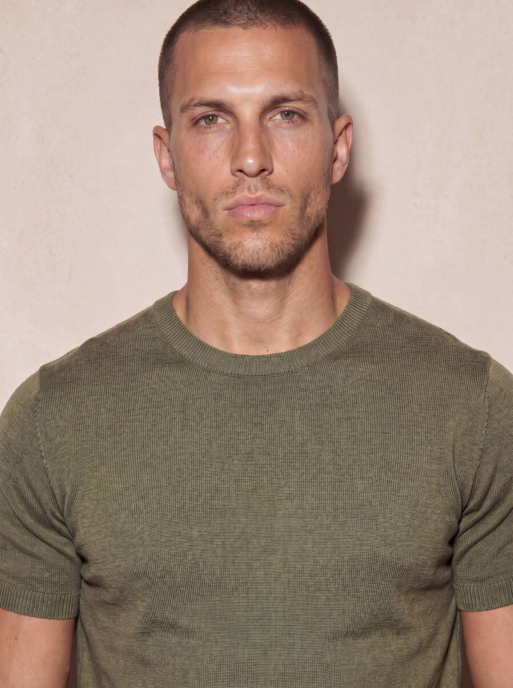 Man wearing olive green Morengar knit t-shirt, close-up